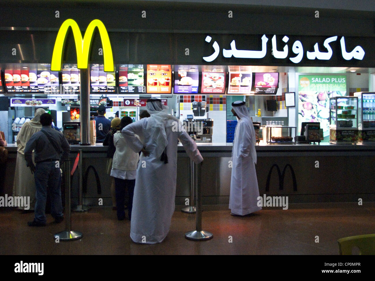 Les hommes en robe arabe traditionnelle au MCDONALD'S, l'aéroport international de Dubai, Dubaï, Émirats Arabes Unis Banque D'Images
