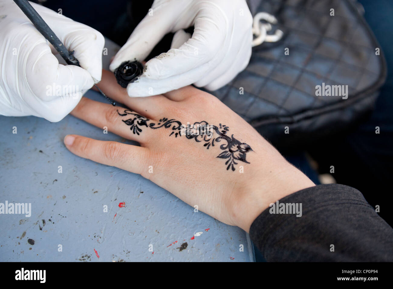 Artiste de rue appliquer henné noir sur la peau des clients. Banque D'Images