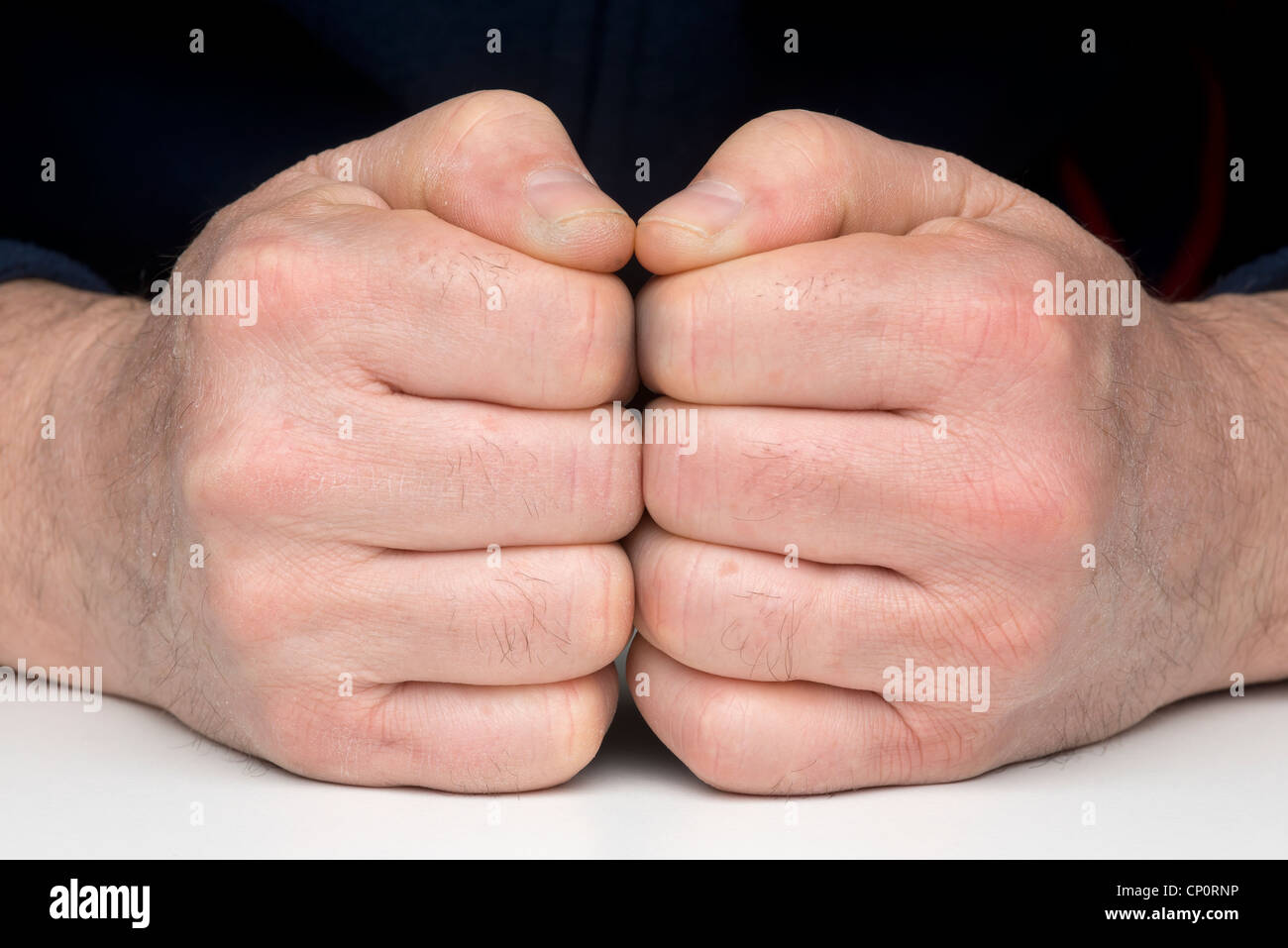 Deux poings fermés sur la table Banque D'Images