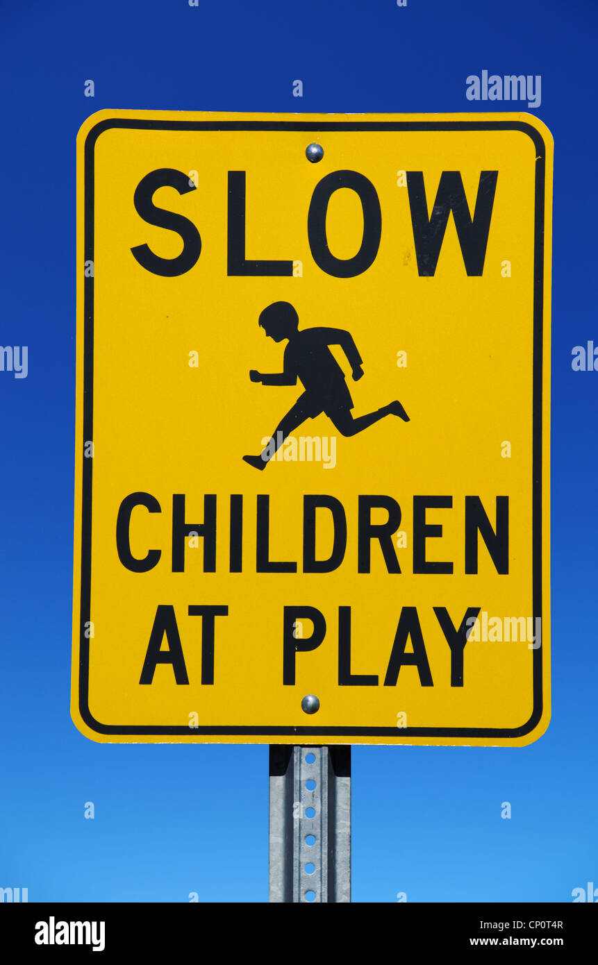 Les enfants lents à jouer street sign avec fond de ciel bleu Banque D'Images