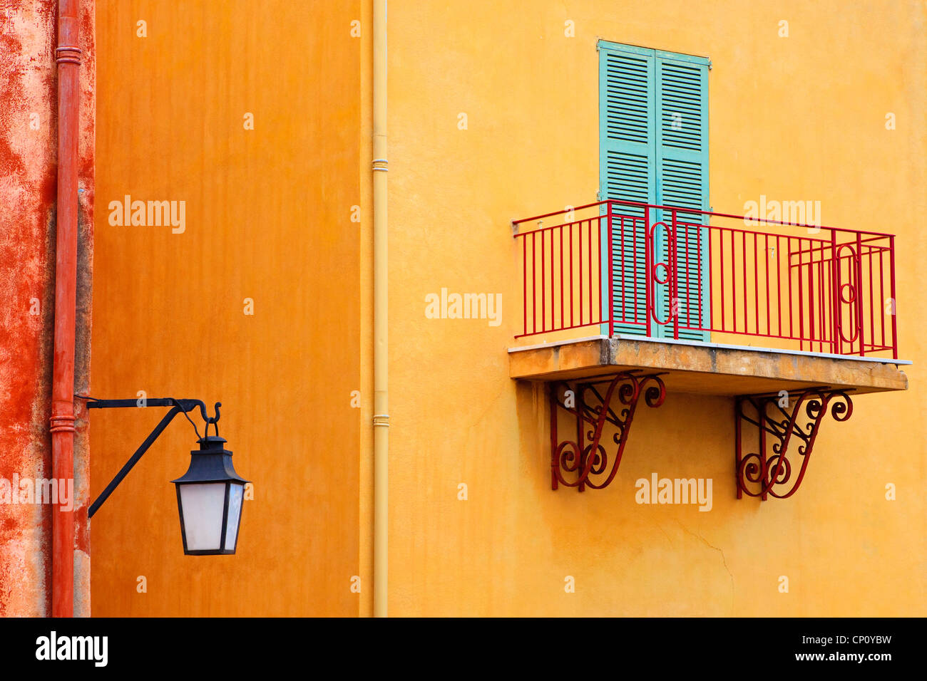 Bâtiment de couleur jaune avec un balcon et de couleur bleu porte à volets, Villefranche-sur-Mer, Côte d'Azur, France Banque D'Images