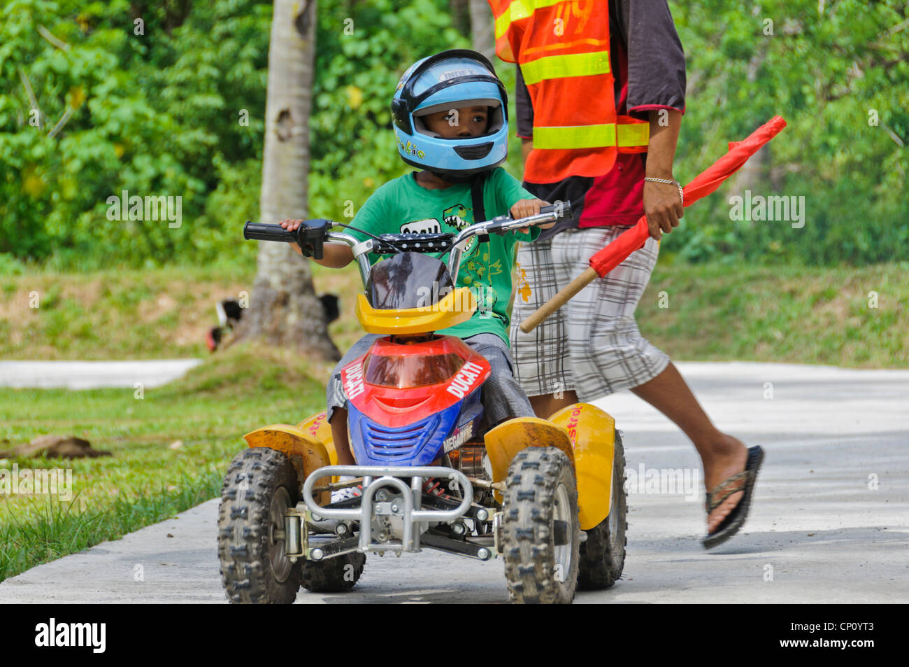 Petit Garçon Asiatique Avec De Grands Enfants équitation Casque Quad