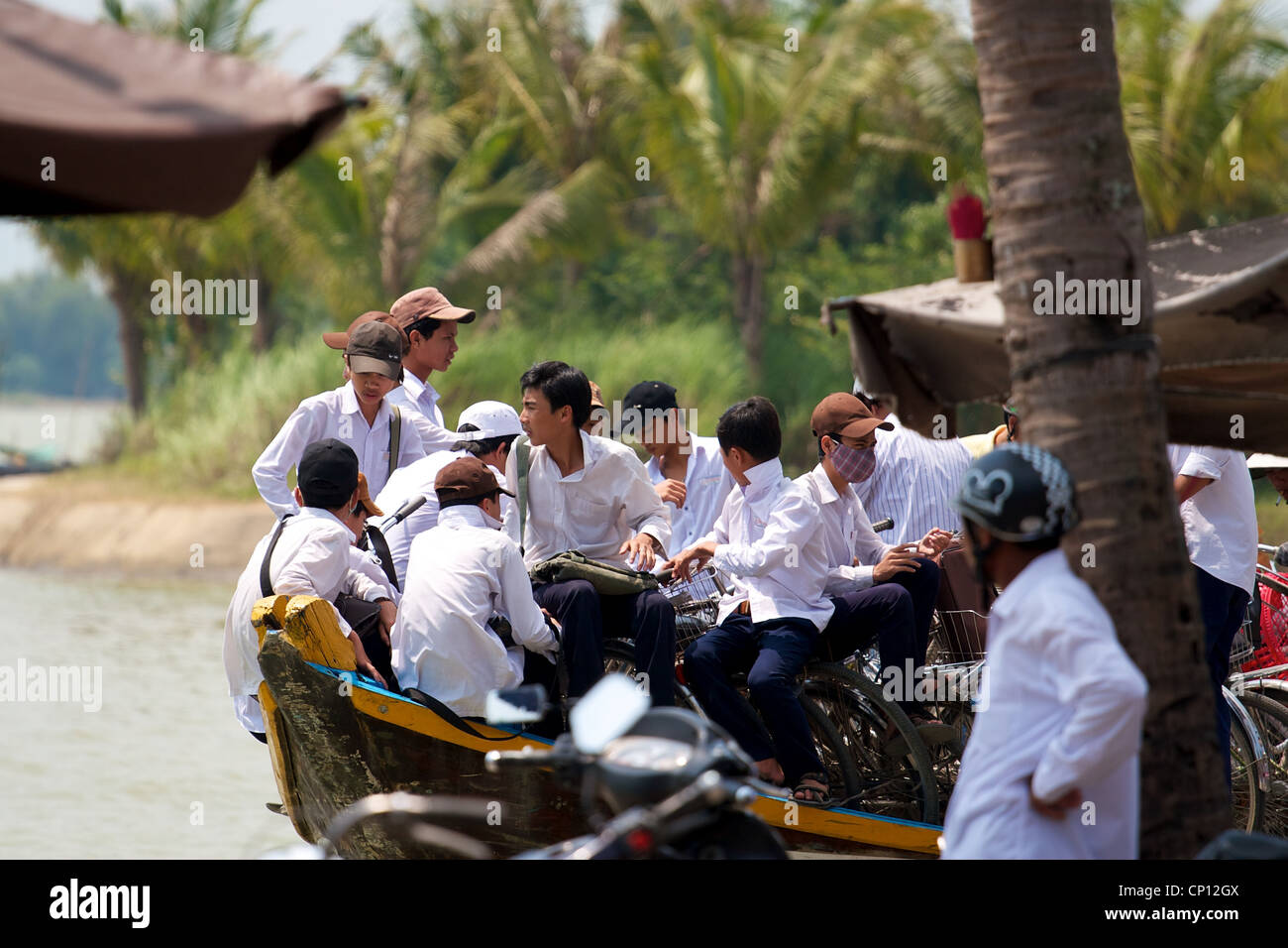 Les garçons de l'école, se rendre à l'école en bateau dans Hoi An, Vietnam. Banque D'Images