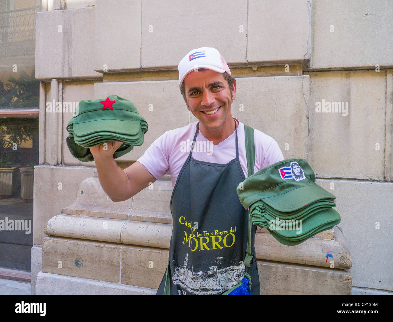 Un homme de 20 à 30 ans contient deux types de chapeaux révolutionnaire  avec ses bras tendus pour la vente aux touristes à La Havane, Cuba Photo  Stock - Alamy