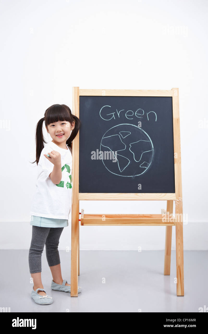 Une fille avec green globe la peinture sur tableau noir Banque D'Images