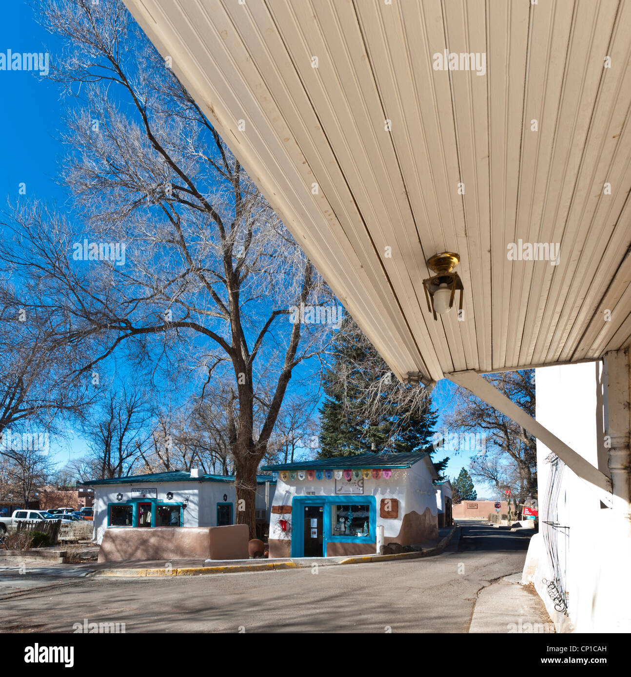 Avis de boutiques aux couleurs vives à Taos, Nouveau Mexique, de sous un grand auvent en bois blanc. Banque D'Images
