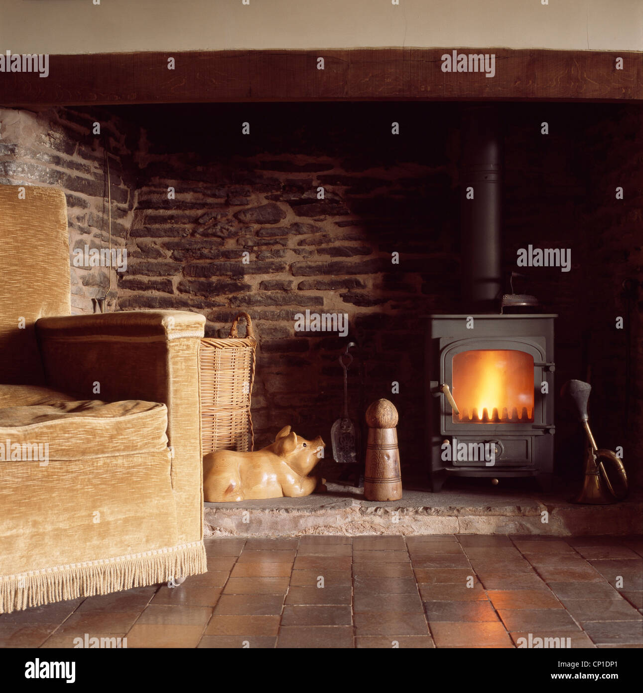Meubles canapé devant le poêle à bois dans cheminée Banque D'Images