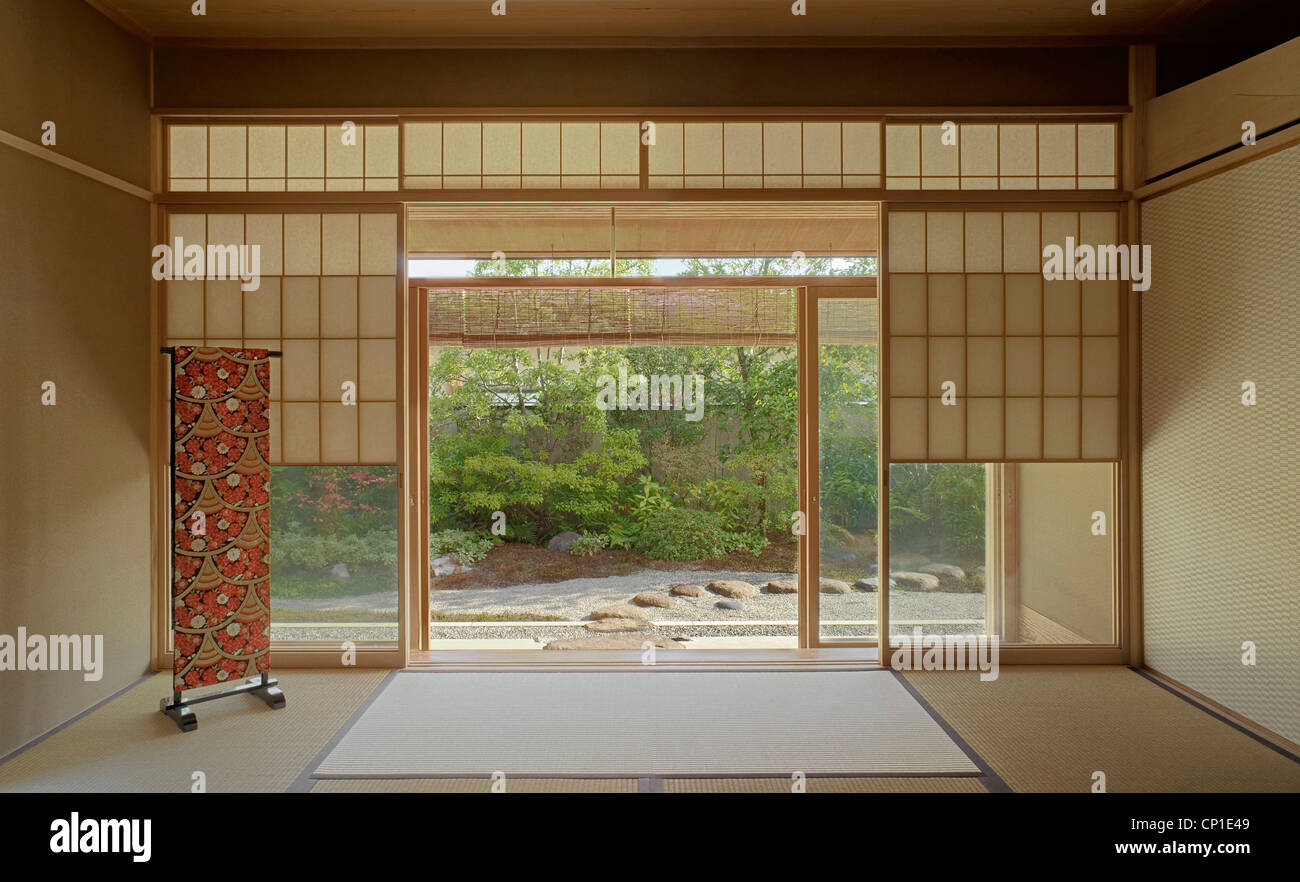 Japonais traditionnellement peu meublée avec vue à travers des portes coulissantes sur jardin Banque D'Images