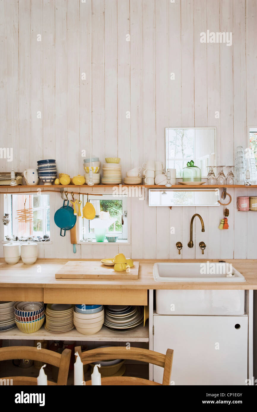 Ustensiles de cuisine sur l'étagère au-dessus de plan de travail en bois  évier ensemble en style rustique avec des murs en bois cuisine Photo Stock  - Alamy