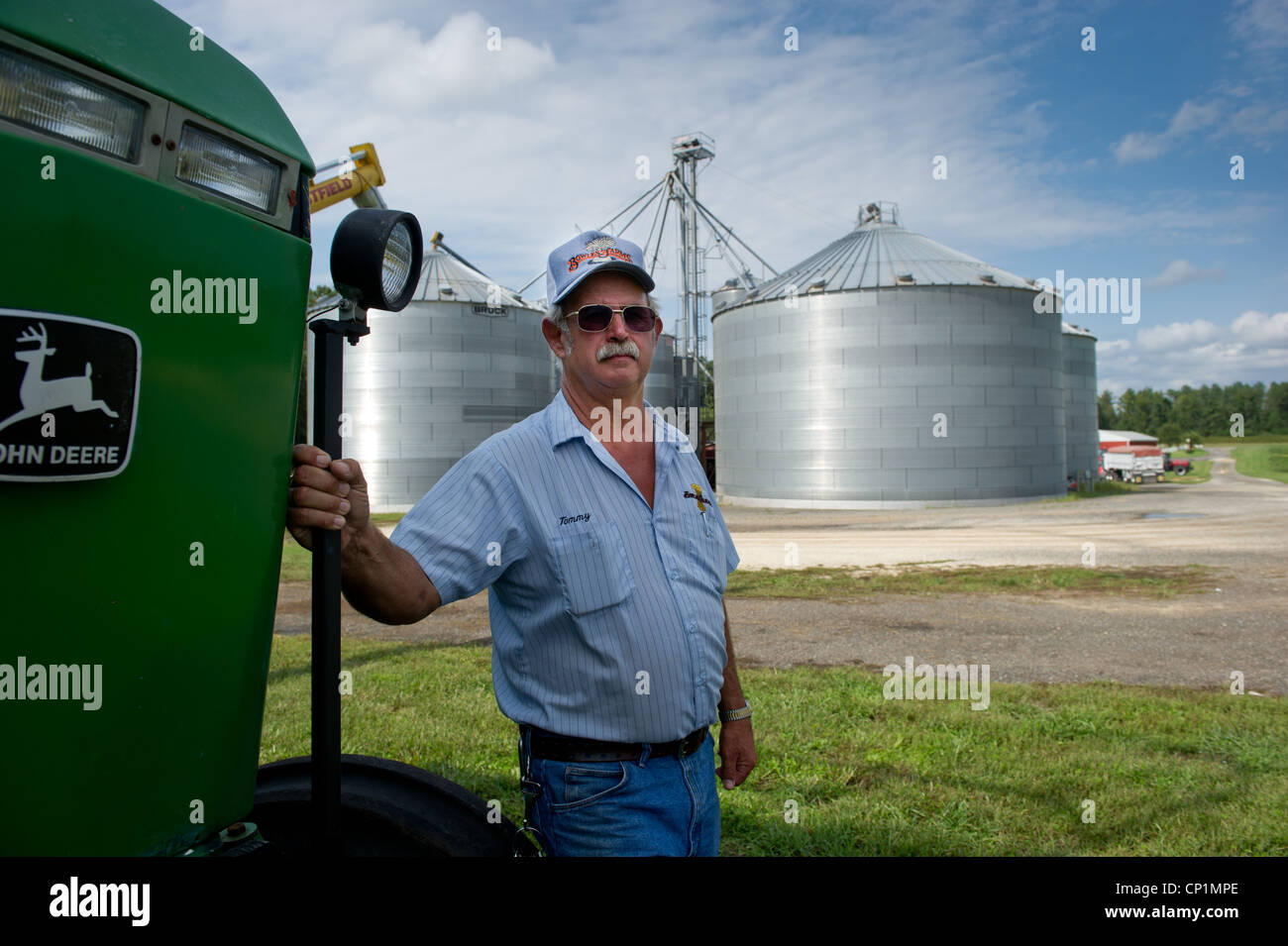 Farmer standing dans l'avant du tracteur et l'opération grain on farm Banque D'Images