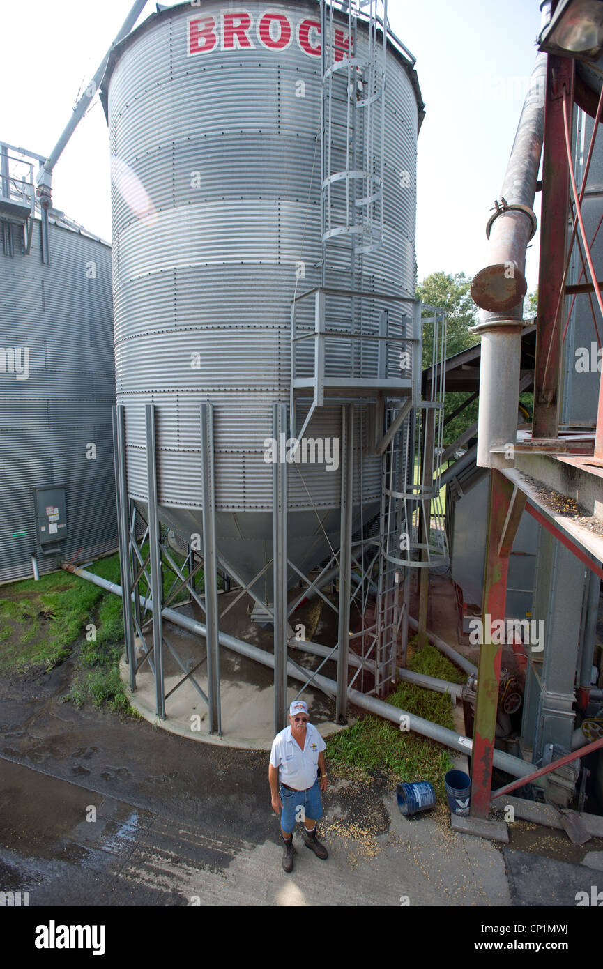 Farmer debout devant des cellules à grains on farm Banque D'Images