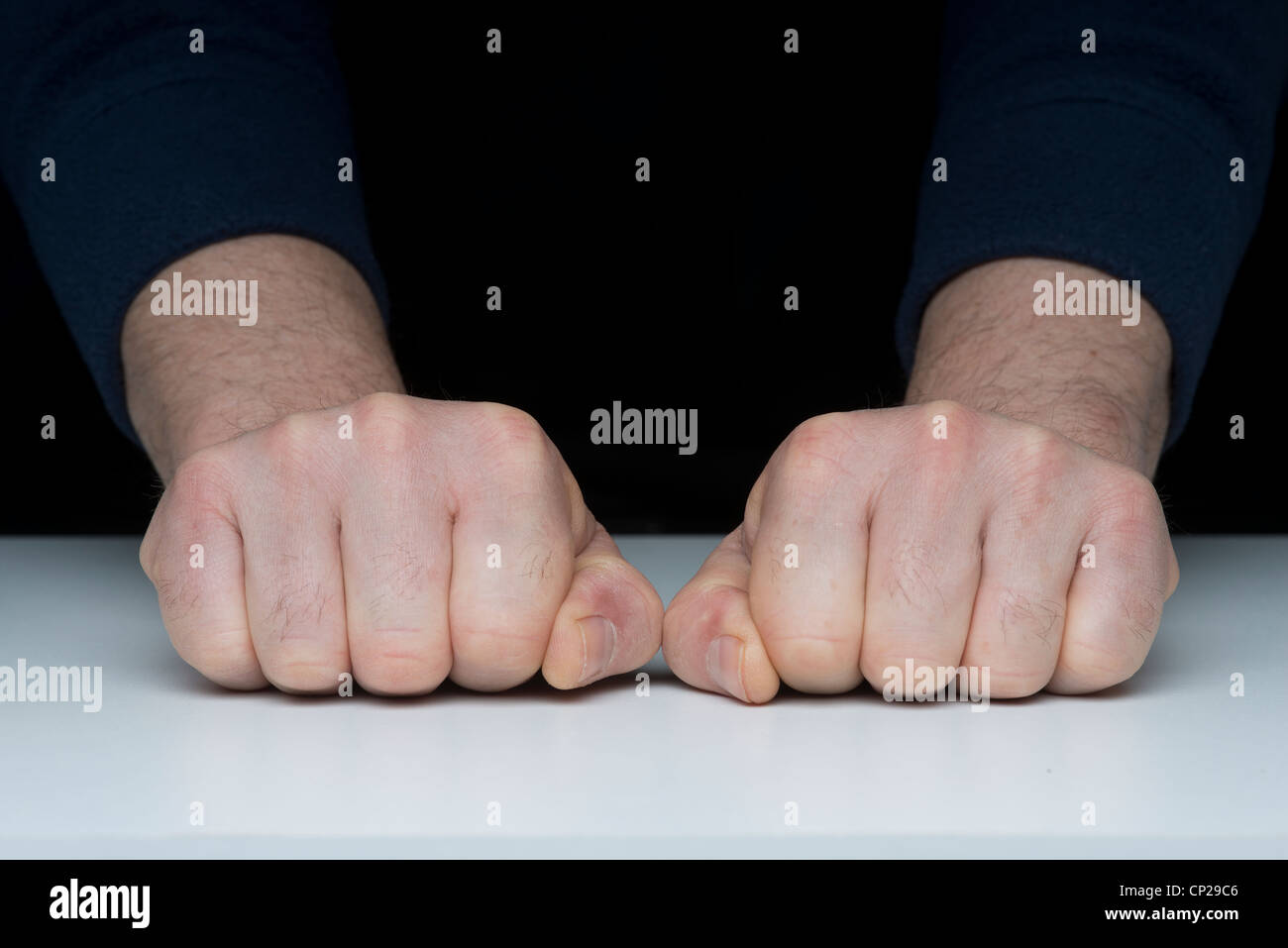 Deux poings fermés sur la table Banque D'Images