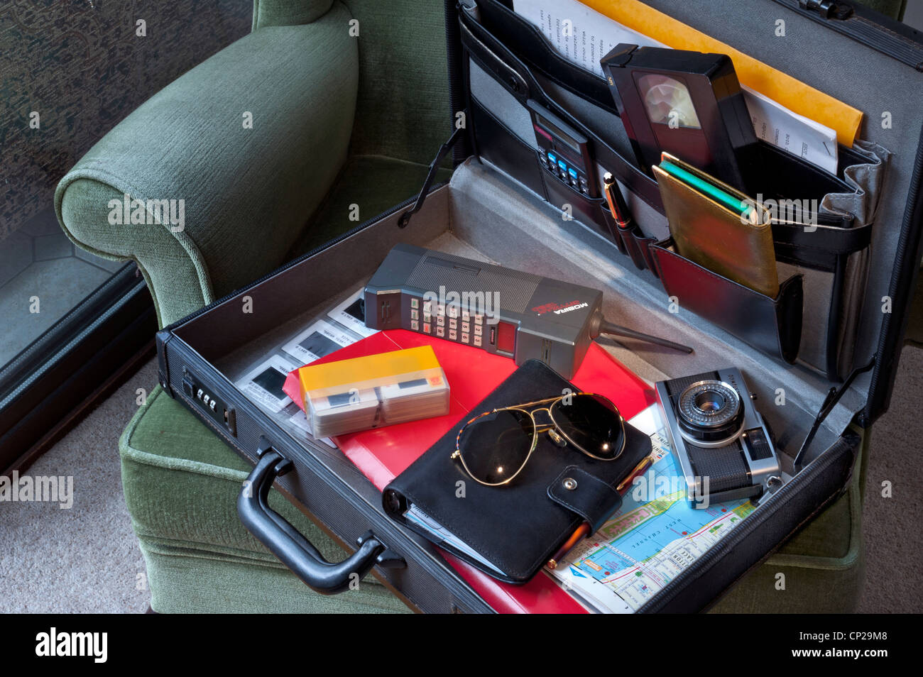Mallette typique de la technologie d'affaires Lifestyle de 1980, téléphone mobile Mobira Cityman, cassette VHS, appareil photo Olympus Trip 35mm, diapositives Kodachrome, etc Banque D'Images