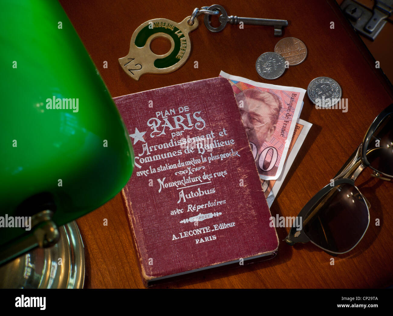 Paris rétro Hotel desk French Francs Holiday concept des années 1950-1960's voyage Art Déco style Paris guide, clé de l'hôtel et lunettes de soleil Zeiss des années 50, France Banque D'Images