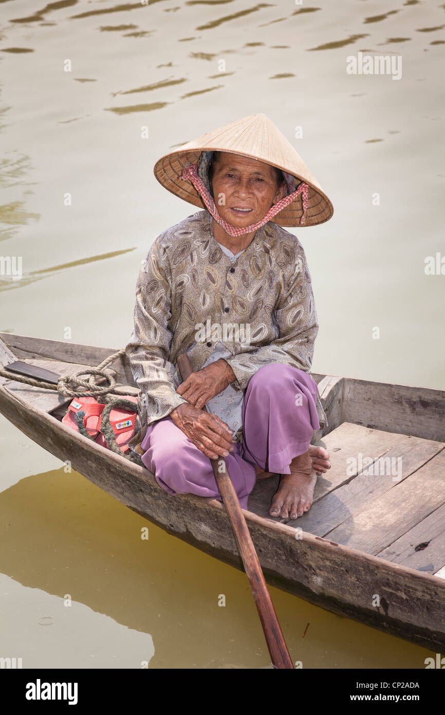 Une vieille femme vietnamienne, assis dans un petit bateau en bois, Hoi An, Quang Nam Province, Vietnam Banque D'Images