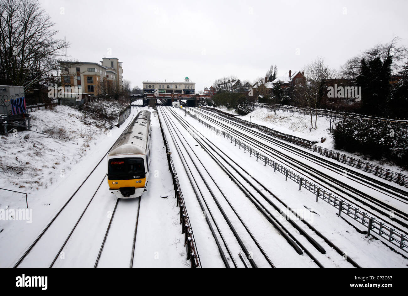 Train de banlieue faire son chemin dans Londres au cours de la neige Banque D'Images