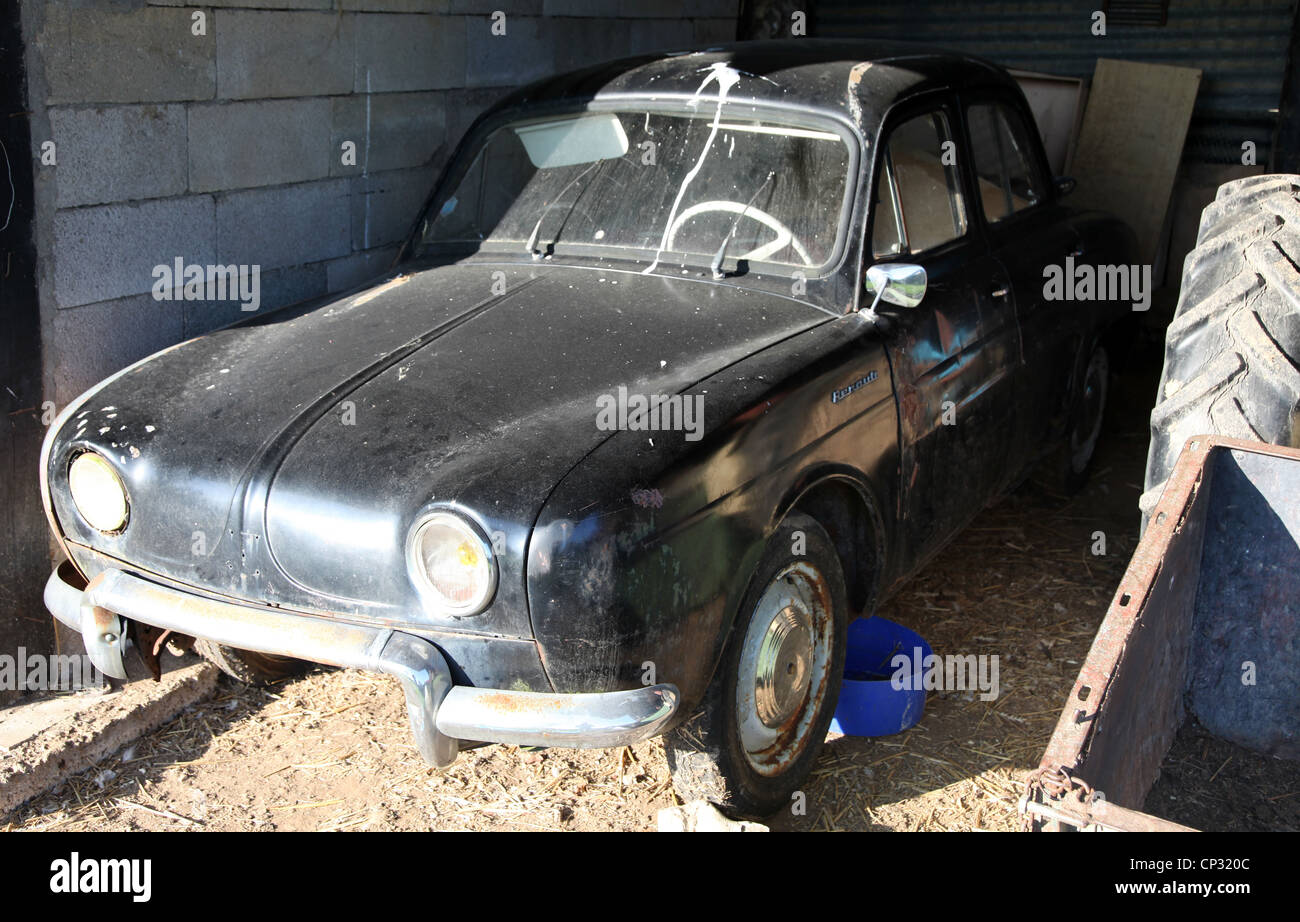 C'est une vieille voiture noire abandonnée dans un garage quelque part dans la campagne profonde dans une ferme en Normandie, France.La voiture est sale cassée. Banque D'Images