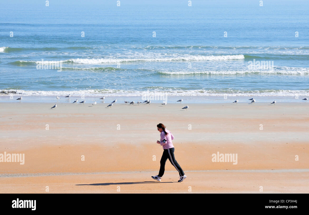 Femme marche à vive allure sur la plage Banque D'Images