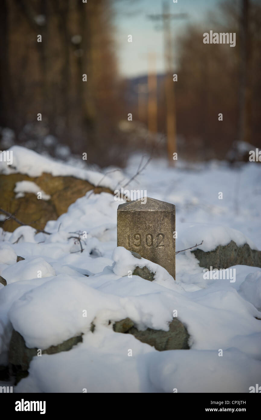 Mason Dixon line marker peeks de sous la neige. Banque D'Images