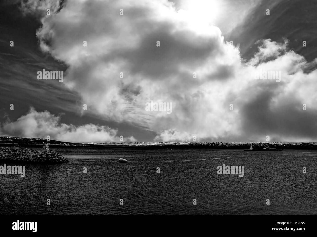 Seascape avec des nuages et un grand pétrolier navire quittant le port en noir et blanc Banque D'Images