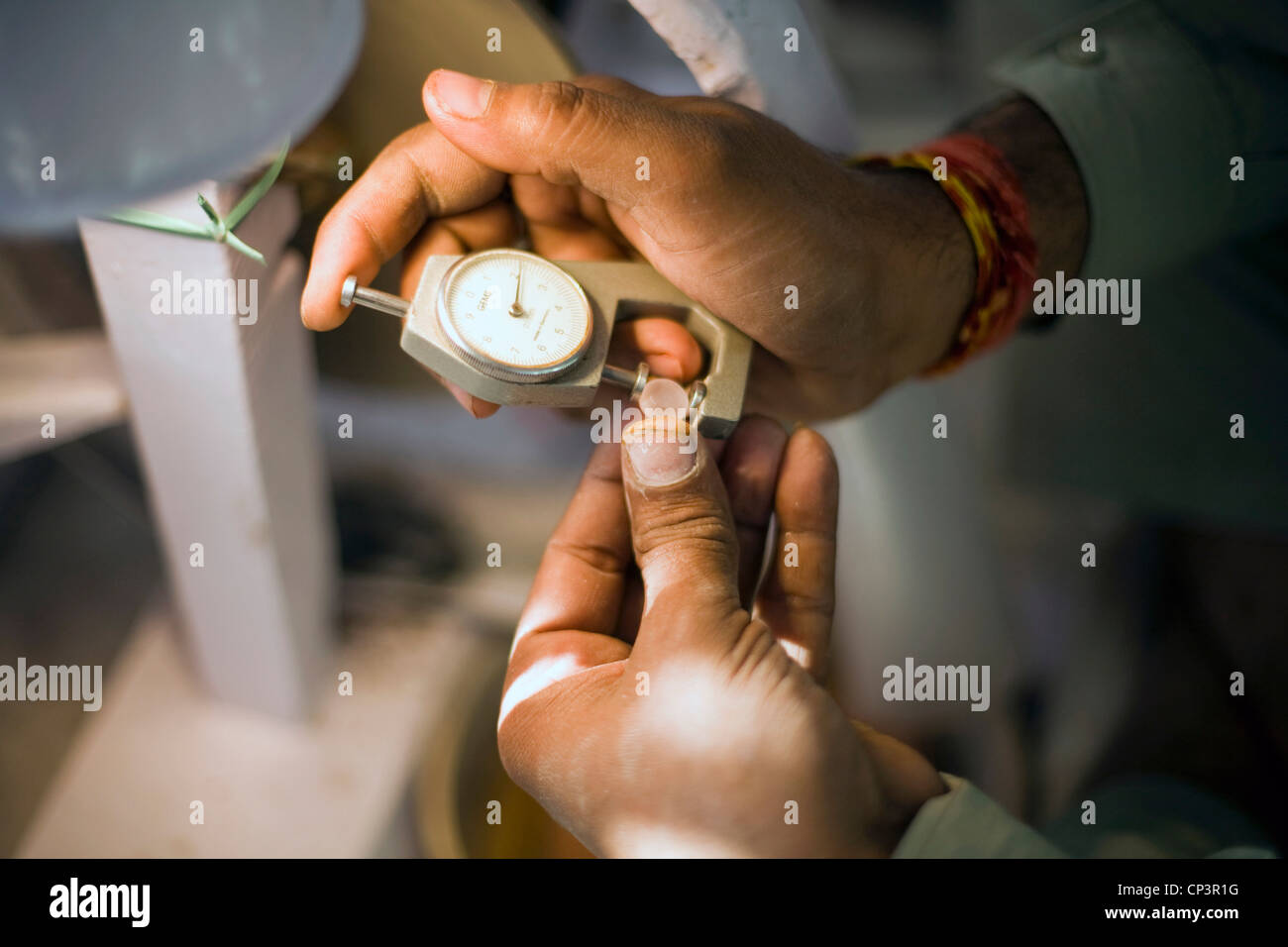 Un travailleur du polissage et mesure de pierres précieuses dans un atelier à la Gem Palace, Jaipur, bijoutiers, Jaipur, Inde Banque D'Images