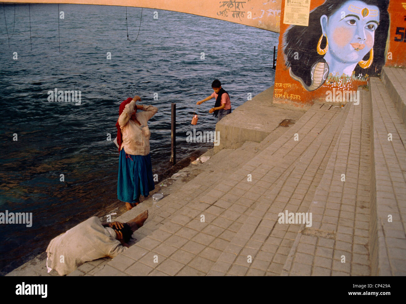 L'Inde Hardwar gens se baignant dans le Gange du Seigneur Krishna de peinture sur le pont Banque D'Images