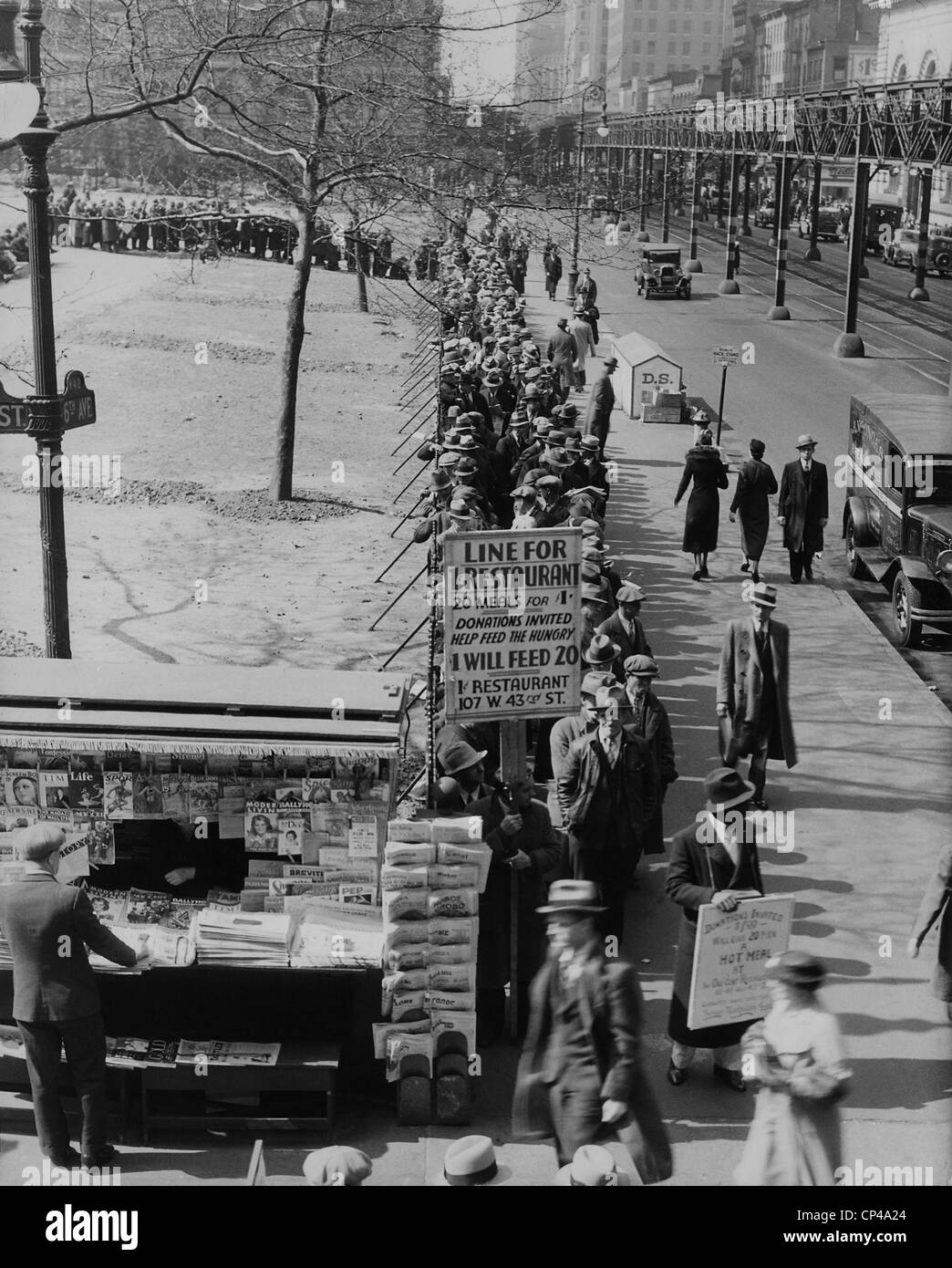 Breadline le long de Bryant Park au centre ville de Manhattan. Un signe pour 1 100 repas annoncés et les demandes de dons. La ville de New York. Banque D'Images