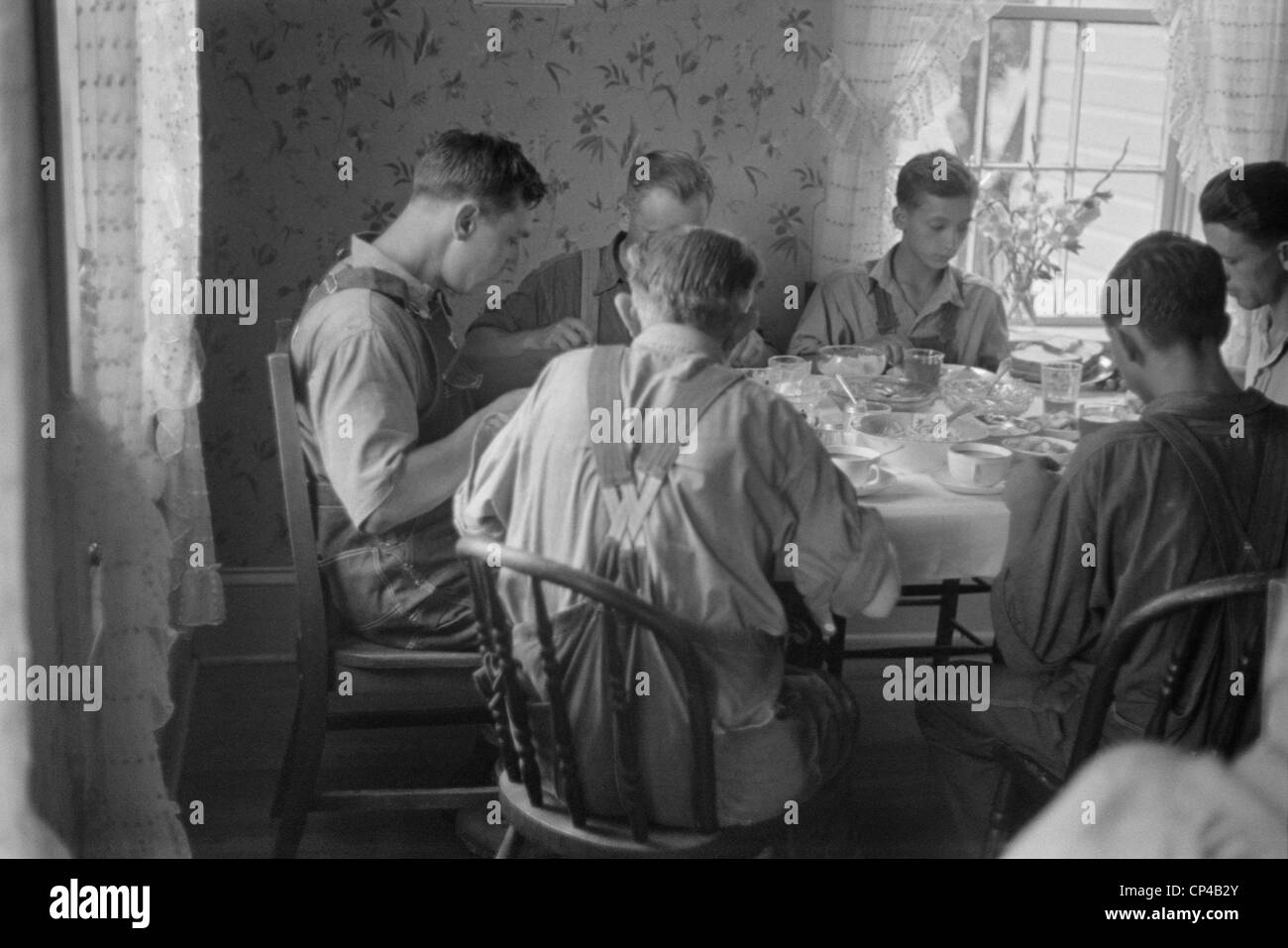 Vieux et jeunes agriculteurs ayant un dîner complet au cours de la période de récolte de blé, le centre de l'Ohio. Août 1938. Banque D'Images