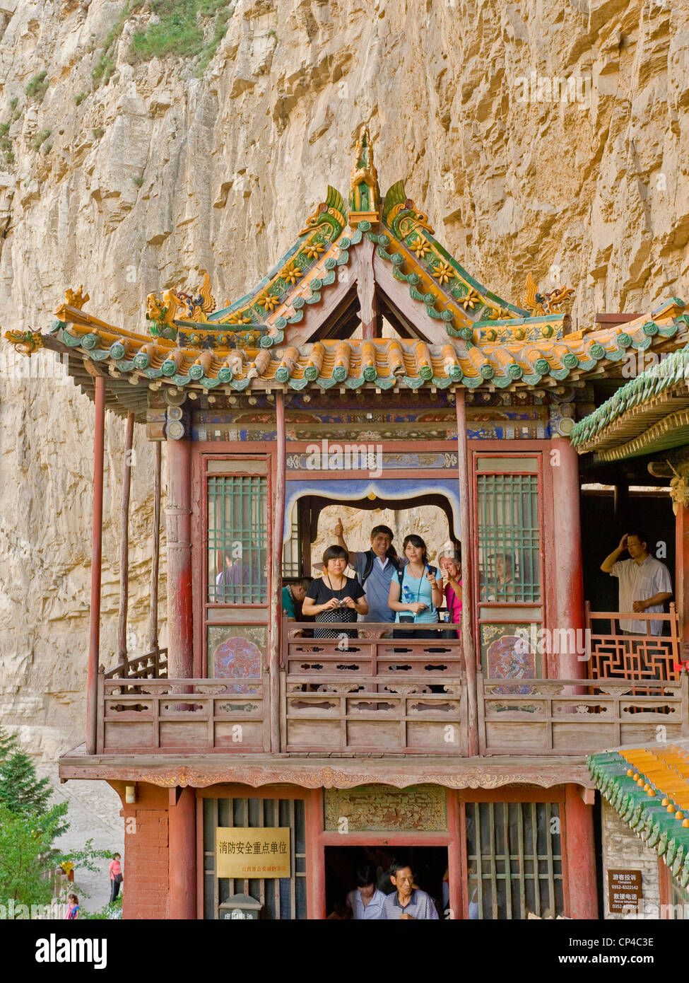 Des touristes posent pour la caméra à la pendaison d'un temple ou monastère suspendu près de Datong. Banque D'Images