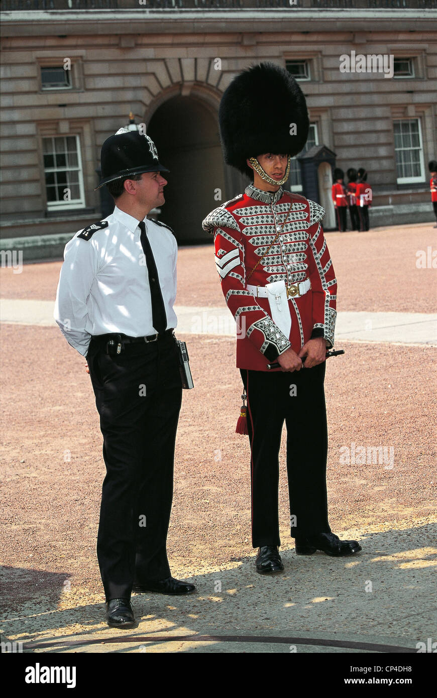 Royaume Uni - Angleterre - Londres, Buckingham Palace. Un garde et un policier. Banque D'Images