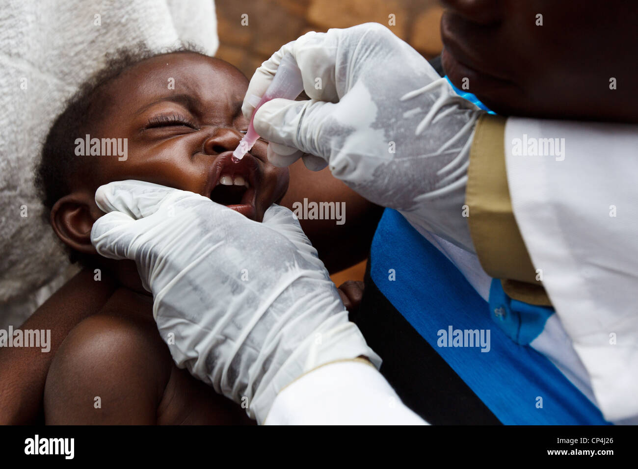 Un enfant reçoit deux gouttes de vaccin contre la poliomyélite au cours de la vaccination de routine à l'Nyunzu centre de santé dans la ville de Nyunzu, RDC Banque D'Images
