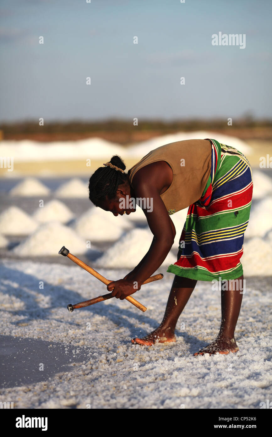 Une femme malgache dans une jupe colorée, casser la croûte de sel au milieu du champs de sel près de Belo sur Mer Banque D'Images