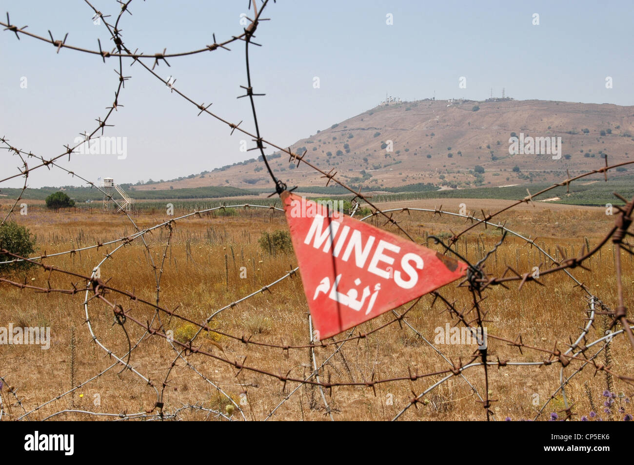 Un champ de mines syrien sur le plateau du Golan, à la frontière avec Israël, avec la station d'écoute du Mont Avital en arrière-plan, Al Quunaitra, Syrie. Banque D'Images
