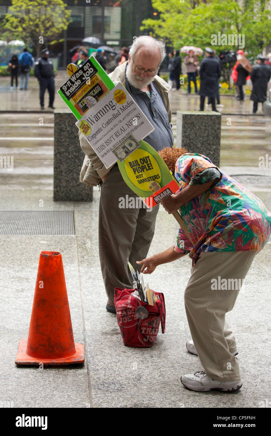 Un manifestant atteint dans son sac pour la littérature d'un passant. Mai 2012 Chicago Journée rallye fédéral, Plaza. Banque D'Images