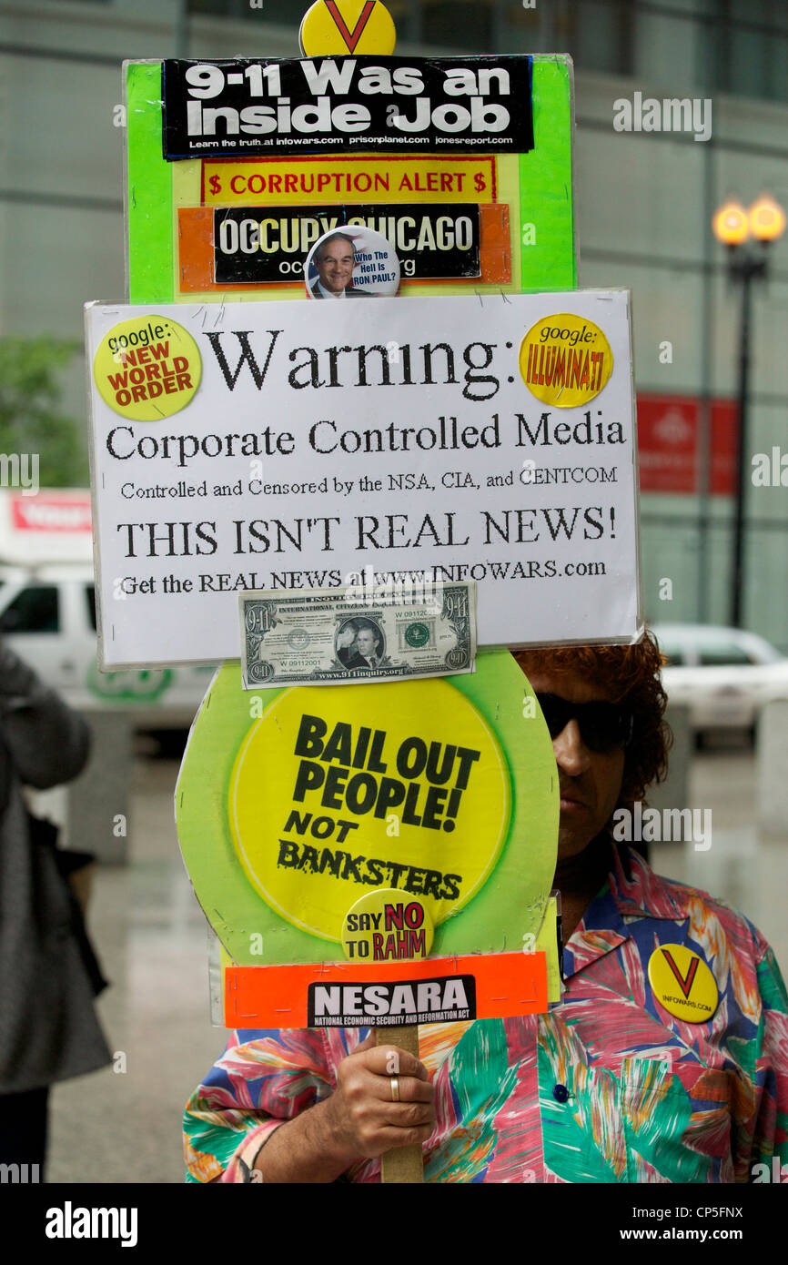 Un manifestant holding sign avec de multiples théories du complot, Chicago May Day 2012 rally, Federal Plaza. Banque D'Images