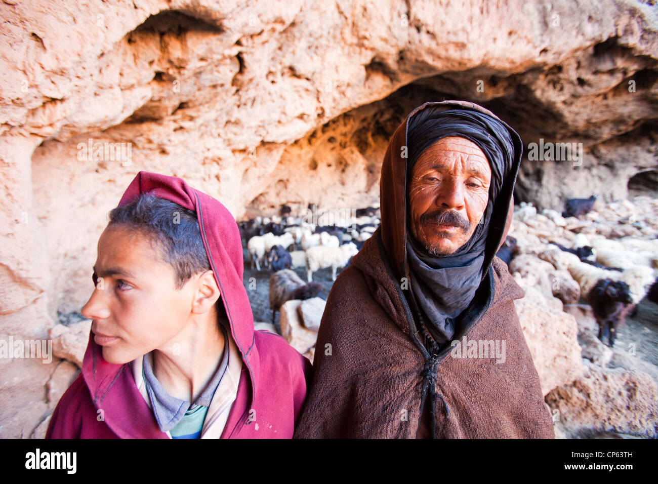 Un berger berbère qui sortent d'une grotte où son troupeau a l'abri pour la nuit dans l'Anti Atlas du Maroc. Banque D'Images