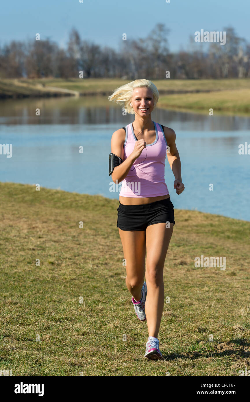 Young woman Jogging loisirs de l'exécutant par river journée ensoleillée Banque D'Images