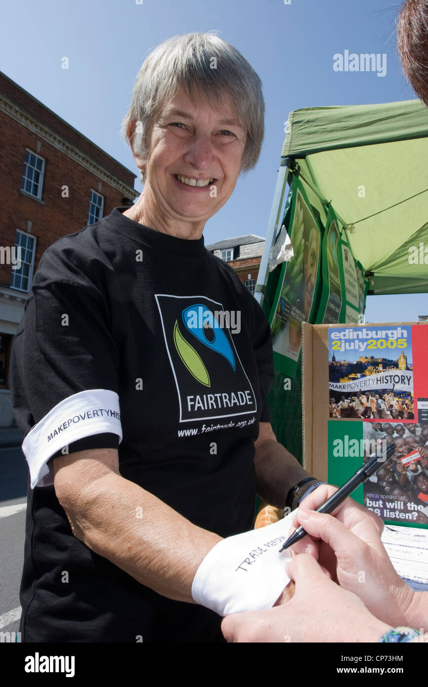 Des bénévoles promouvoir les produits du commerce équitable sur un stand à Devizes, Wiltshire Banque D'Images