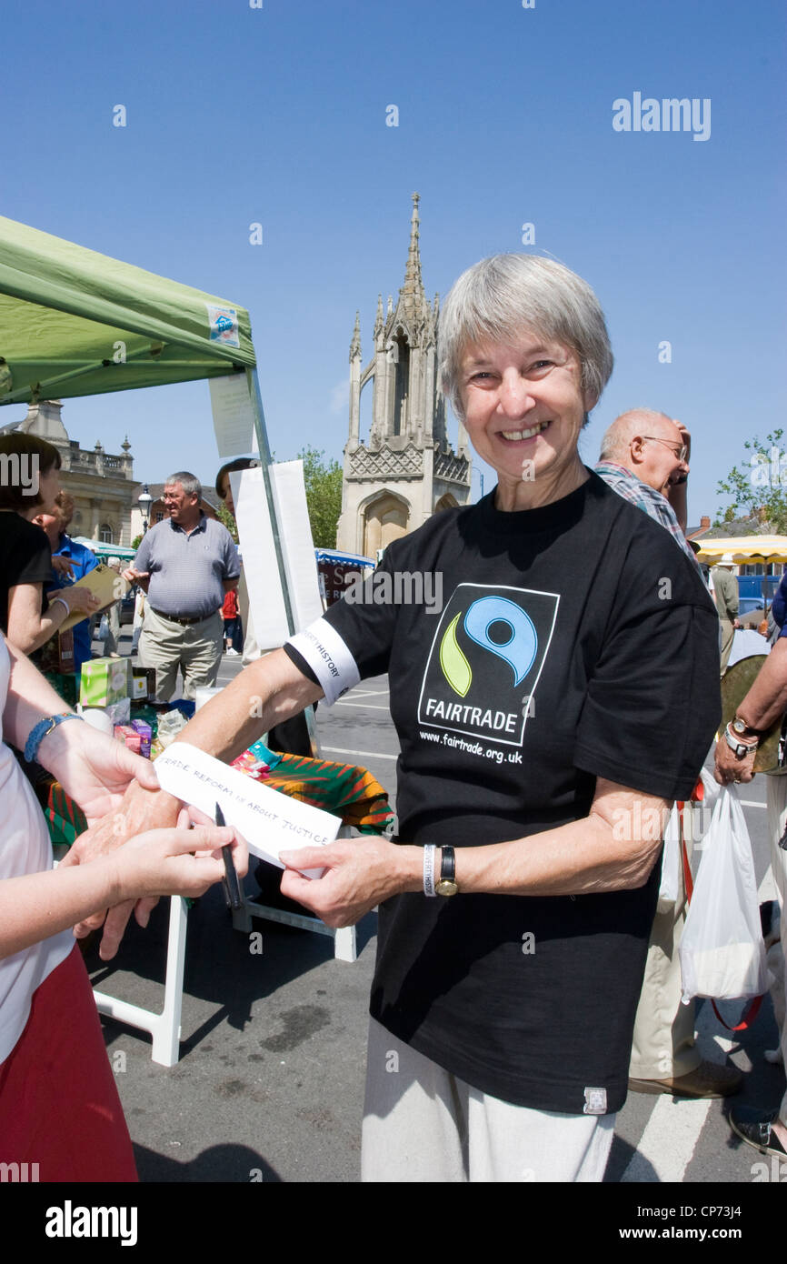 Des bénévoles promouvoir les produits du commerce équitable sur un stand à Devizes, Wiltshire Banque D'Images