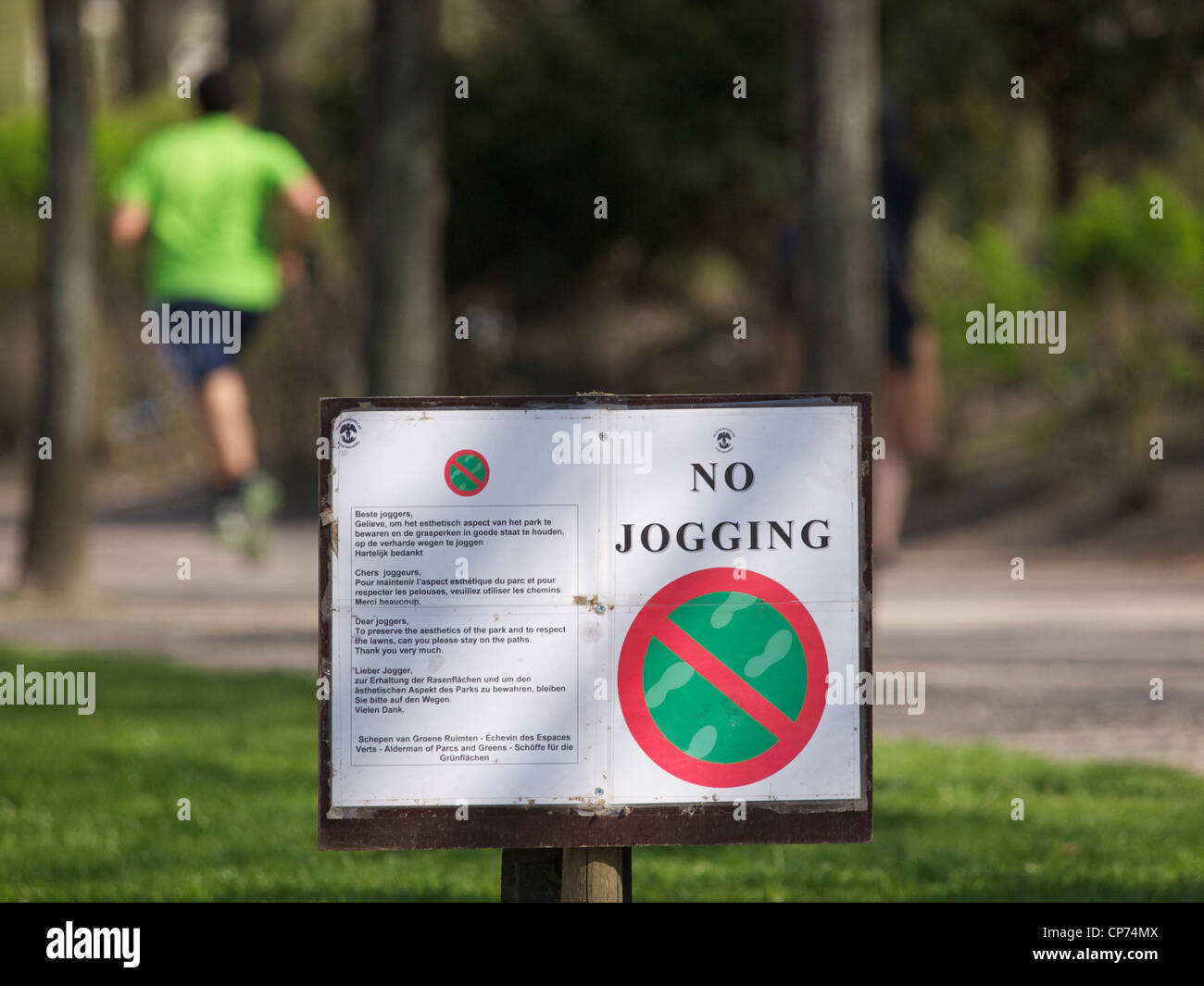 L'absence de décalage sur les pelouses de signe sur la Warande park à Bruxelles, Belgique, avec jogger dans l'arrière-plan Banque D'Images