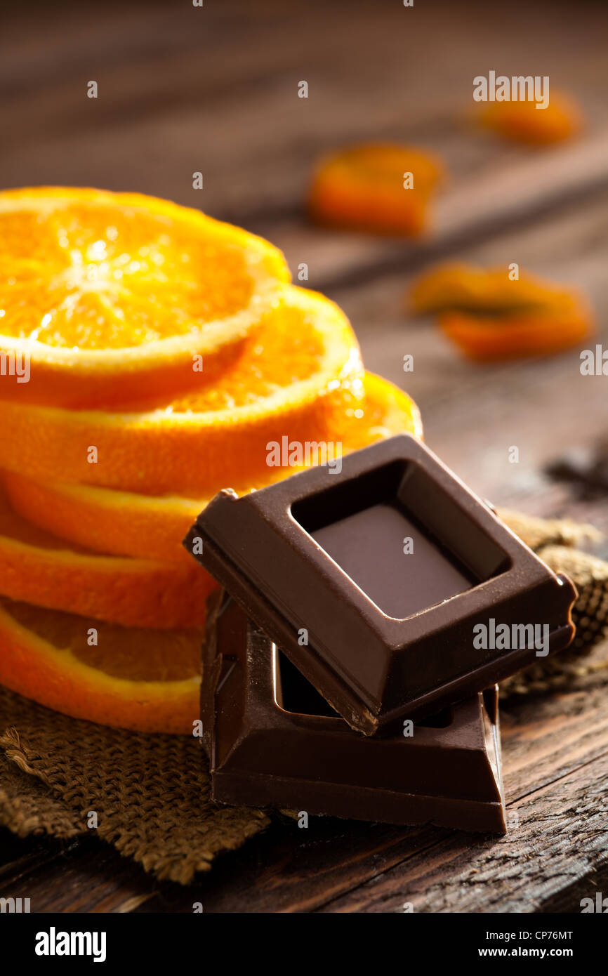 Des carrés de chocolat avec des tranches d'Orange sur le jute et le bois Banque D'Images