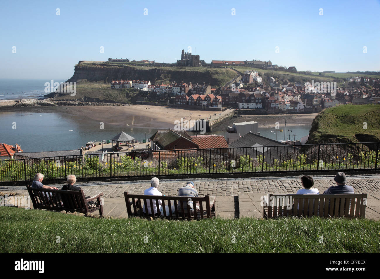 Les touristes tout en observant le soleil à Whitby, à la recherche de l'autre côté de la baie avec l'abbaye dans la distance. Le Yorkshire, en Angleterre. Banque D'Images
