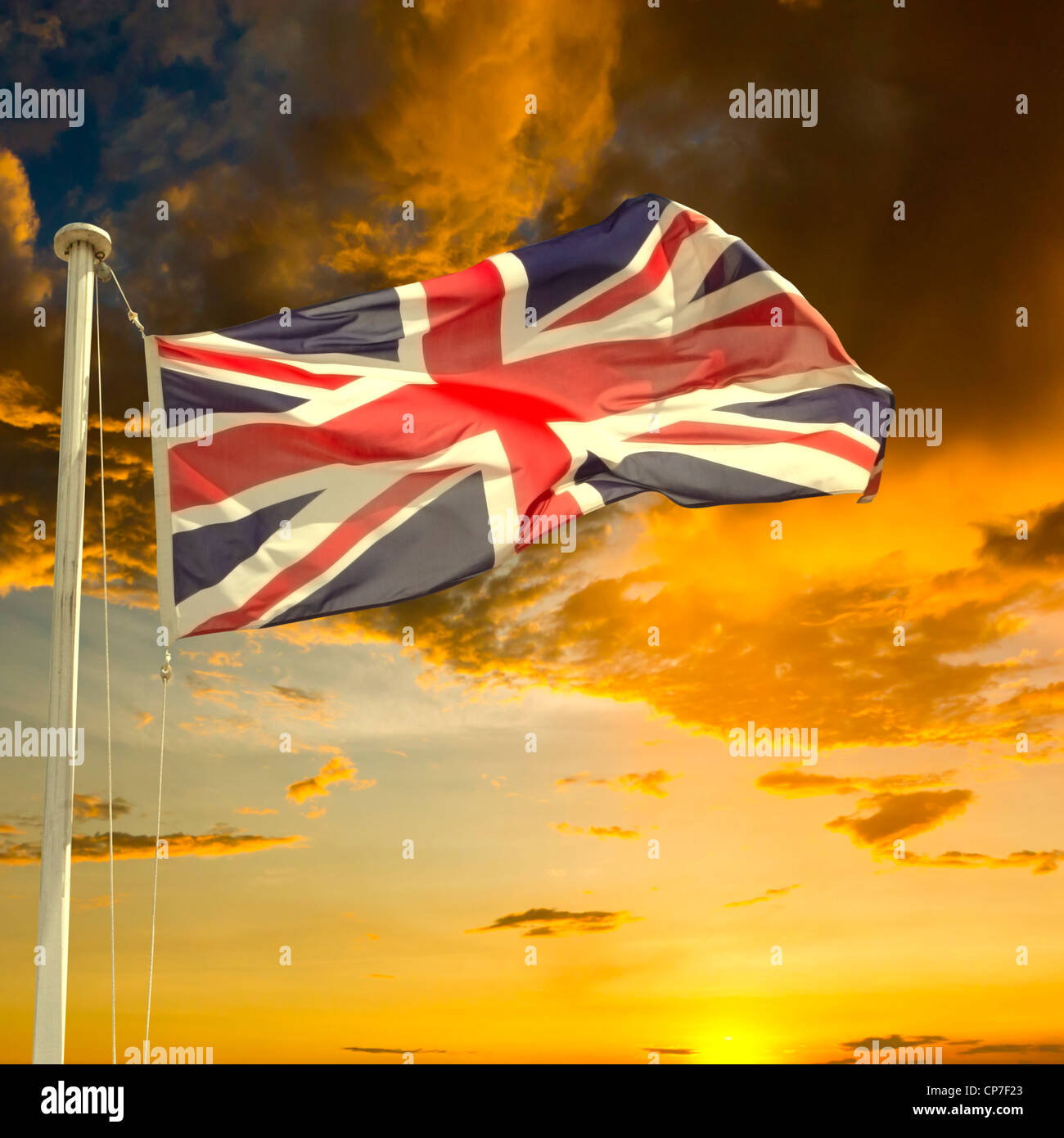 Brexit concept. Drapeau britannique (Union Jack) se dirigeant du mât sous ciel couvant sombre au coucher du soleil. Banque D'Images