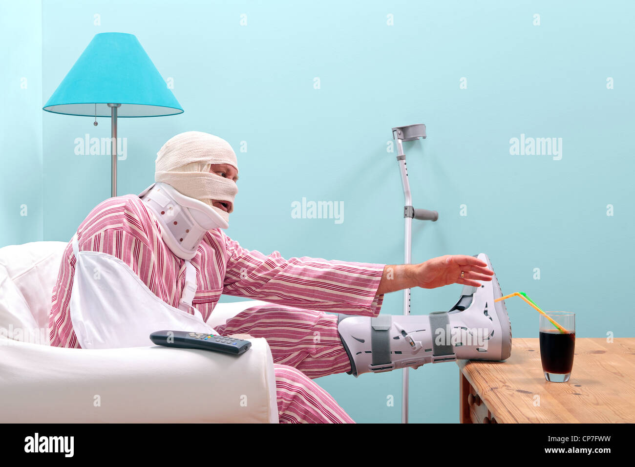 Photo d'un homme blessé en pyjama avec une jambe, la tête bandée, le bras en écharpe et neck brace Banque D'Images