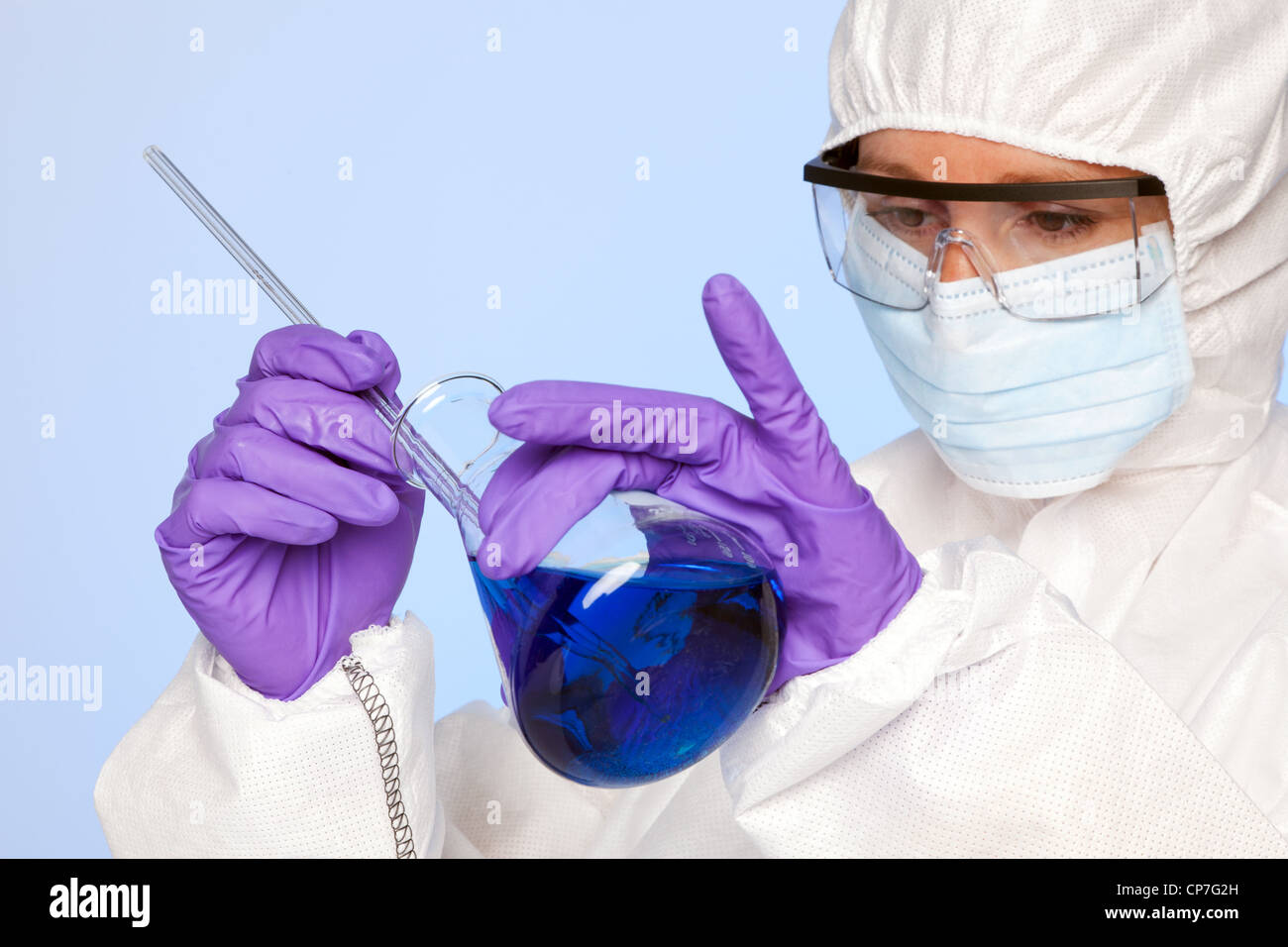 Photo d'un biochimiste Lab technician holding une fiole de produits chimiques et d'une tige de verre Banque D'Images