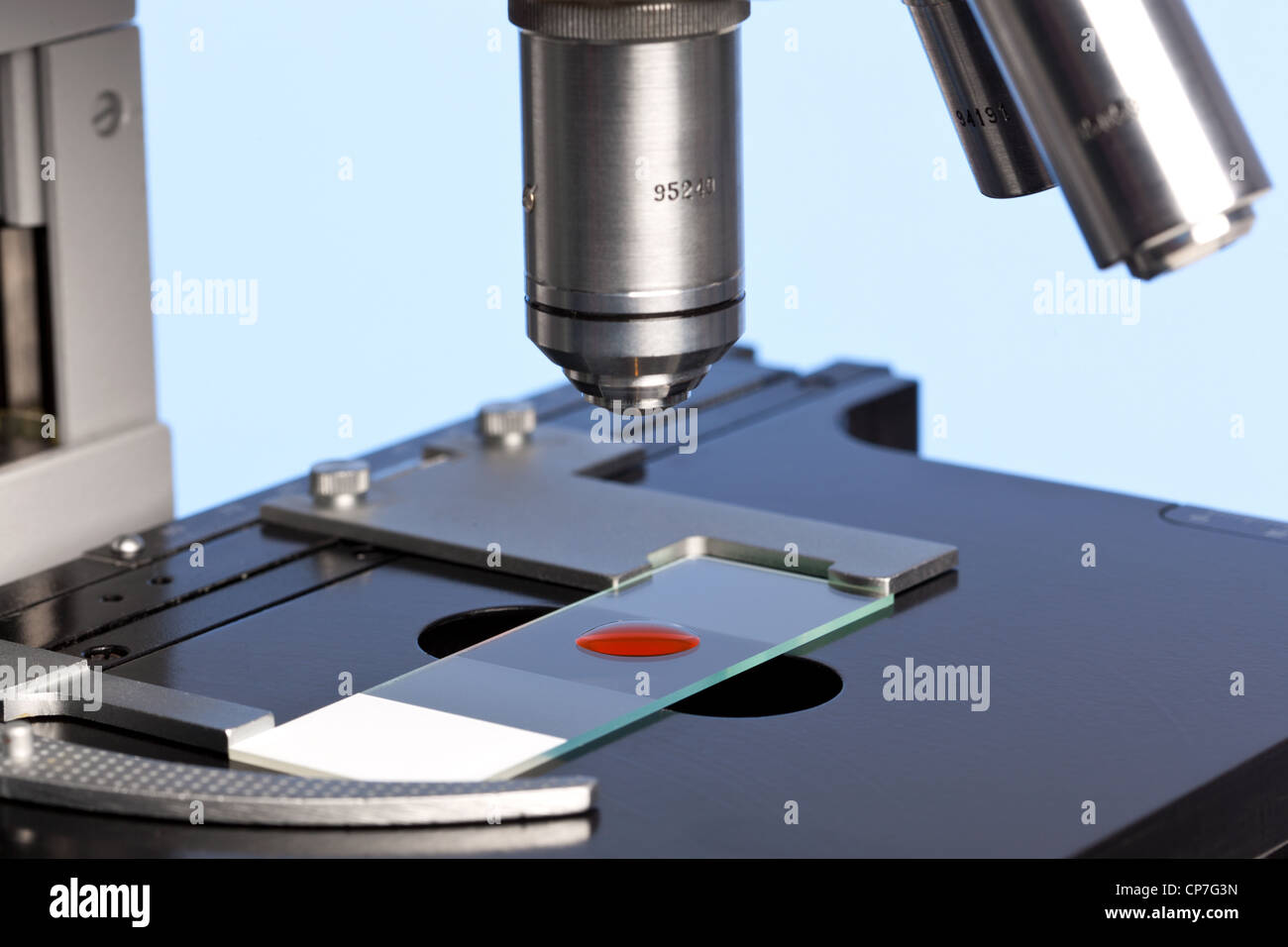 Photo d'un microscope de laboratoire avec un échantillon de sang sur une lame de verre. Banque D'Images
