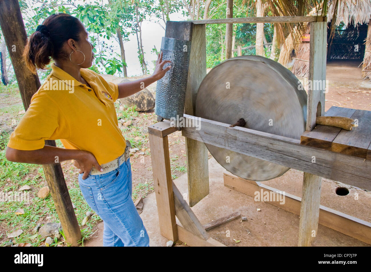 Un guide démontrant une machine à fraiser racine de manioc dans le Kalinago Barana Aute showcase village Dominique Banque D'Images