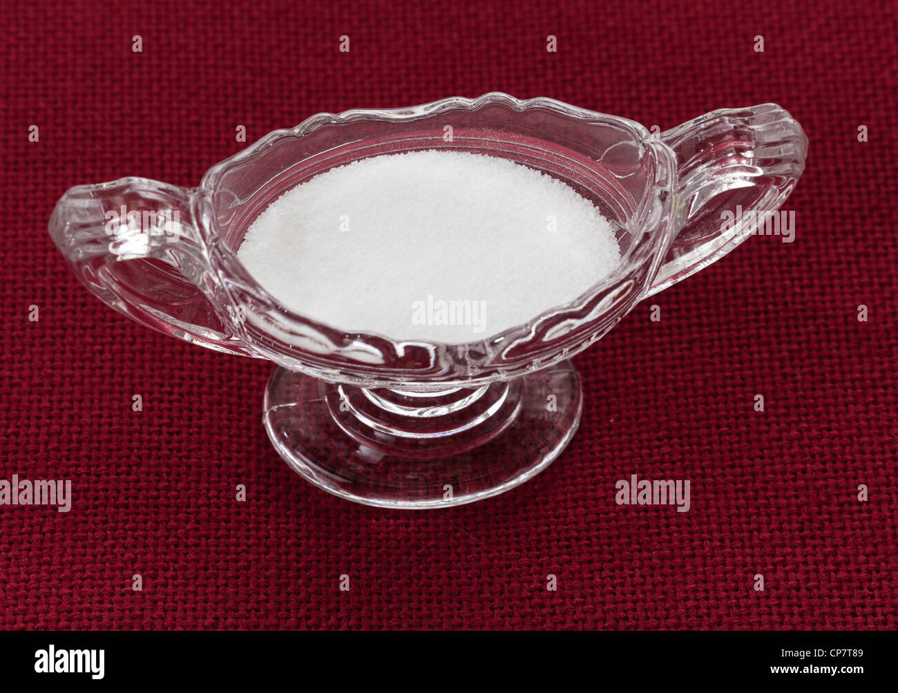 Les cristaux de sel de table de coupe en bol en verre sur nappe rouge Banque D'Images