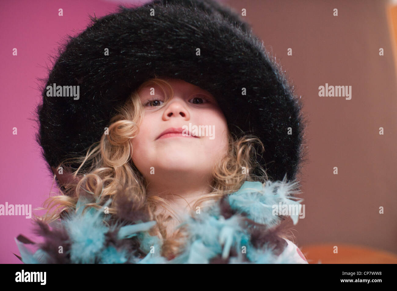 Quatre ans, fille essaie sur costume de fantaisie et chapeau bas. Banque D'Images