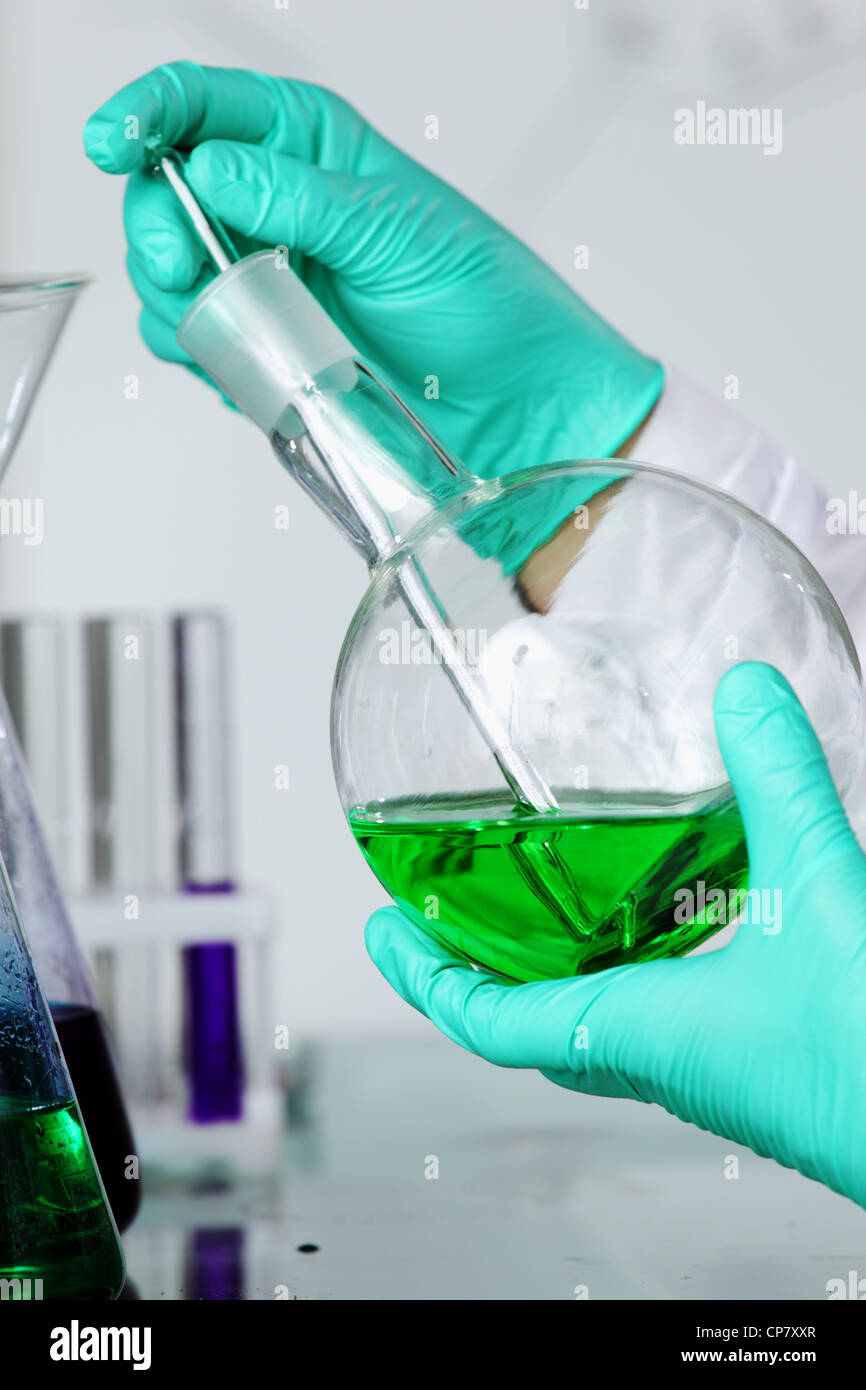 La fiole avec un liquide chimique substance dans les mains de l'expert scientifique en chef Banque D'Images